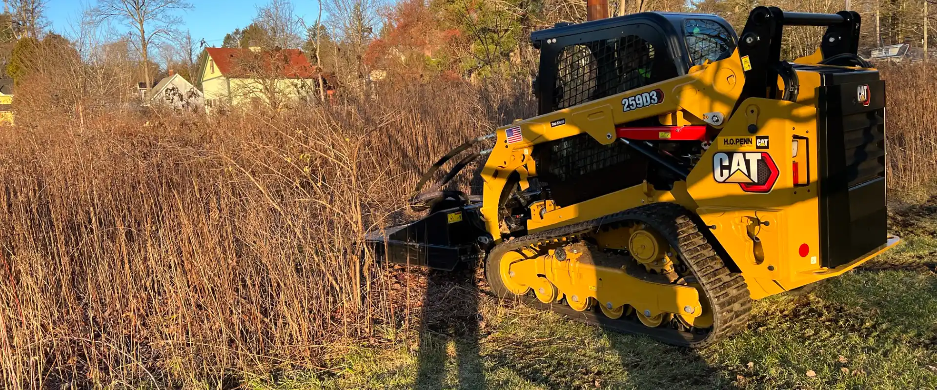 yellow contruction machine with some grass and a house at the back on windsor Locks ct